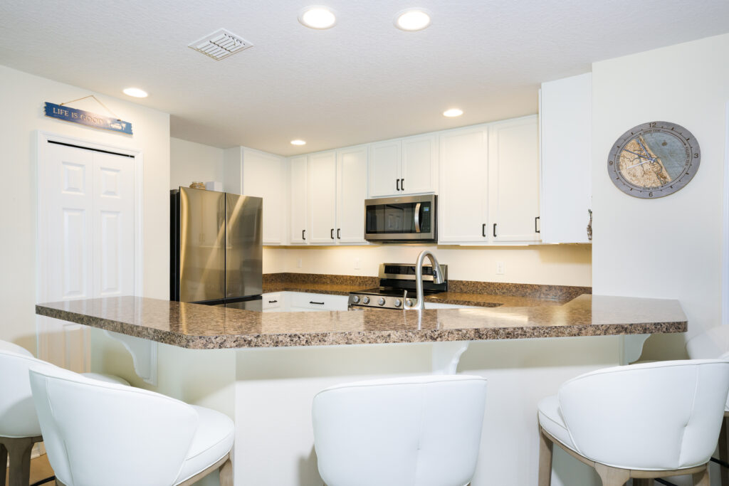 White spray-finished cabinets in New Smyrna Beach beach house with a clean, coastal style